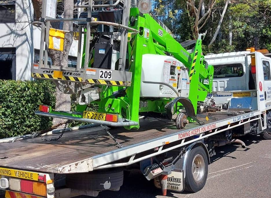 Machinery with no wheels is being transported in Sydney by a tow truck.