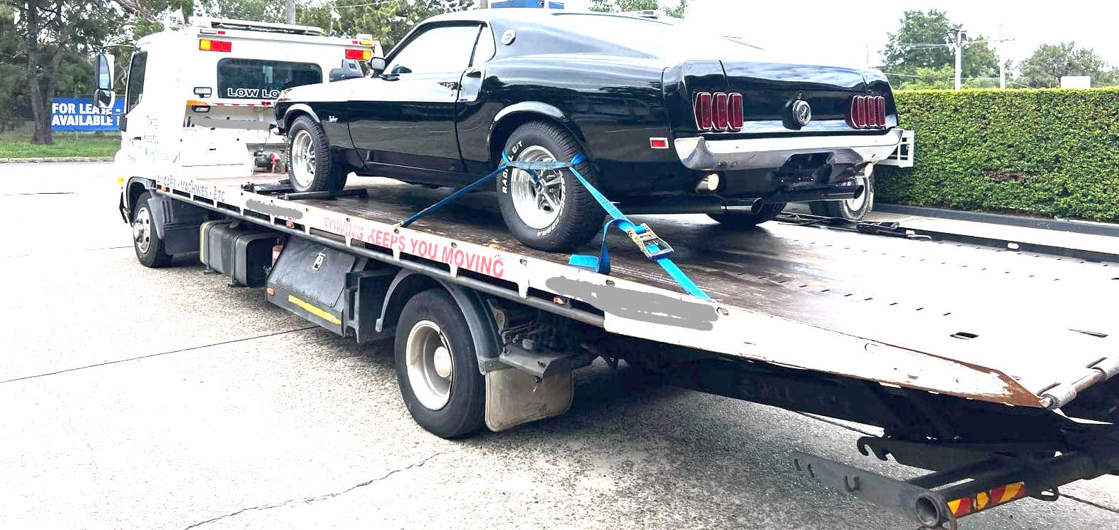 A tow truck carrying a mustang heading to North Shore Sydney.